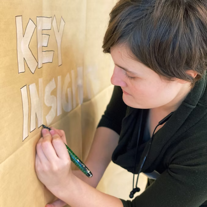 Graphic artist Angela Krieg hand-lettering a live event poster